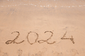 A hopeful inscription of '2024' in the beach sand, capturing the essence of a new year full of possibilities.