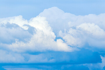 Big fluffy blue clouds on the dramatic sky close up