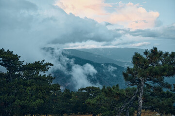 Fototapeta premium Scenic Mountain View with Clouds and Trees in the Foreground Serenity and Beauty of Nature Landscape Travel Inspiration