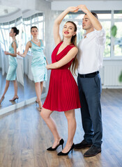 Guy and girl in stage costumes, under guidance of mentor, practice boogie woogie in choreographic studio. Ballet dancers during personal training session. Professional rendering of dance entertainment