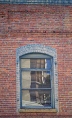 Red and White Brick Wall with an Arched Window.