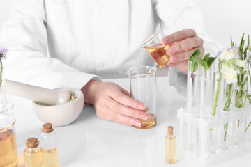 Aromatherapy product. Scientist developing essential oils at white table in laboratory, closeup