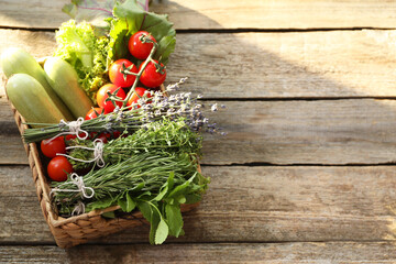Different aromatic herbs and vegetables on wooden table. Space for text