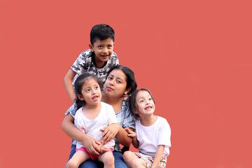 Young Latina mom with 2 daughters and a son show their love with kisses and hugs to celebrate...