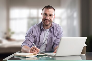 Happy teenager guy studying with laptop computer