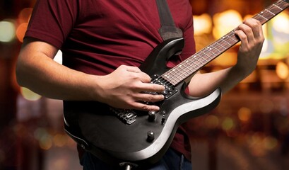 A guitarist plays on guitar during a band's performance.