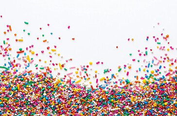 Colorful sprinkles scattered on white background