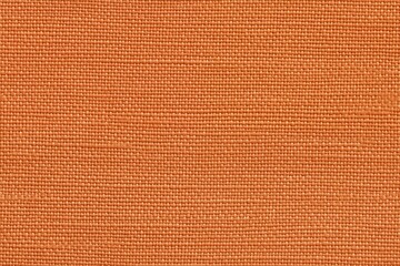 Fototapeta premium Textured orange batiste cotton fabric, showcasing a woven pattern and a warm hue.