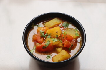 Tomato Batata Rassa Bhaji, tangy curry made with tomato, potato, cononut and spices, dish from Konkan Maharashtra, India, served with rice or flat bread