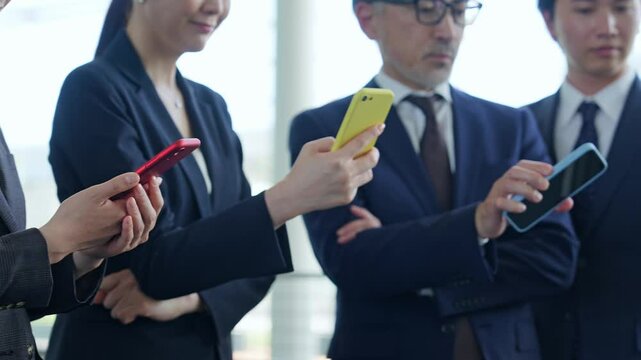 スマホを使うビジネスパーソンのグループ