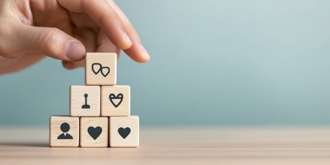 A hand stacking wooden blocks with icons representing various emotions and connections, symbolizing relationships and growth.