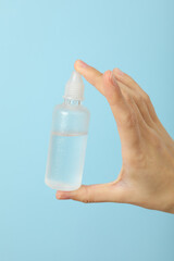 A bottle with liquid for lenses in his hand