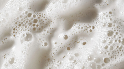 Close-up of a shampoo bottle with thick white foam, bubbles gently resting on the surface.