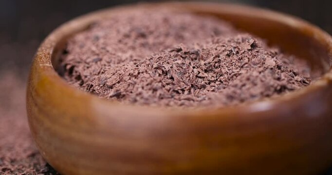 chocolate crumbs in a wooden bowl, round wooden bowl with chocolate pieces and chips