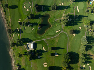 Fototapeta premium A golf course with a pond and a clubhouse