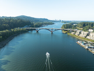 Obraz premium A boat is traveling across a river near a bridge