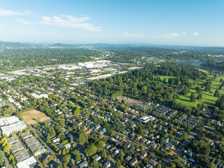 A city view from above with a lot of houses and a golf course