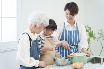 キッチンで料理をする三世代家族