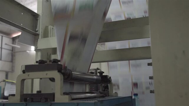 A busy book printing factory operates efficiently, with machines printing, binding, and packaging books through an automated process