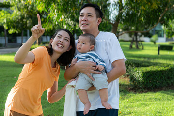 Parents with little child are having fun and resting in a park