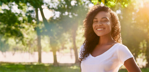 An open and natural portrait of a Black woman wearing a white shirt
