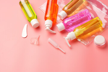 Clear Plastic Bag Containing Travel-Sized Toiletries on Pink Background