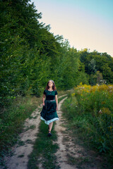 Fototapeta premium woman in whimsical aesthetic style dress in field in summer at sunset