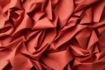 Obraz premium Crumpled red fabric creates intricate textures and abstract shapes, offering an artistic and visually striking composition suitable for backgrounds or design projects.