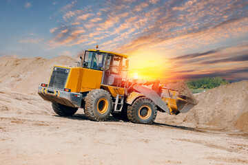 Obraz premium Industry mining, yellow excavator work in sand quarry, sunlight. Rental of construction equipment.