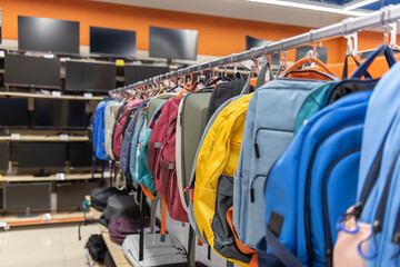 A rack of backpacks and a few computer monitors