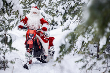 Santa Claus in red cloth riding on snow bike, motorcycle with ski background snow forest. Concept delivery gift for Christmas holiday.