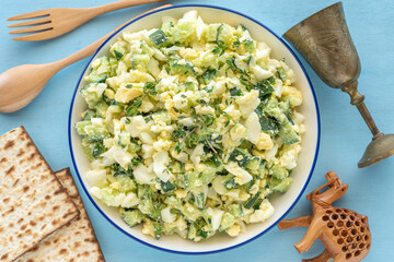 Egg Cucumber Thyme Salad for Jewish holiday Pesach (Passover) on the background of traditional symbols and food.

