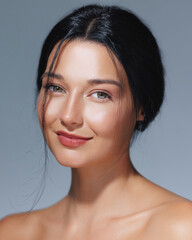 Fototapeta premium Smiling Woman with Radiant Skin and Natural Beauty Against Blue Background
