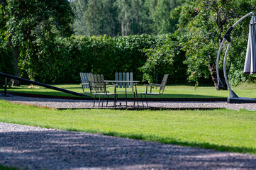 Garden furniture standing on gravel in beautiful garden