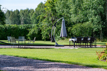 Fototapeta premium Garden furniture standing on gravel in beautiful garden