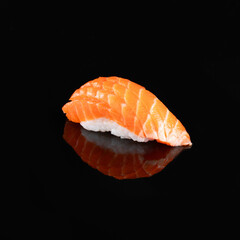 Close-up of a delectable salmon nigiri sushi garnished with a delicate topping, isolated on a dark background