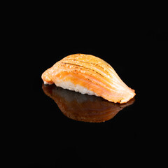 Close-up of a delectable salmon nigiri sushi garnished with a delicate topping, isolated on a dark background