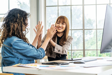 Collaboration of graphic design business people with computer in an office company. Two corporate women in creative marketing team working on project management , high five after a job is completed