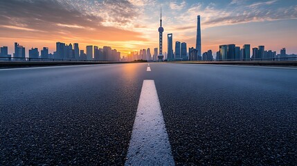 Asphalt Road Leading Towards a Modern Skyline at Dawn