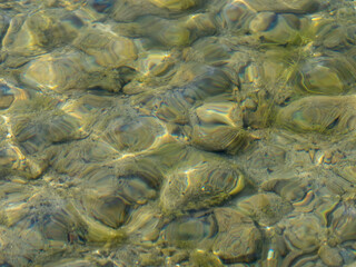 The view from the air on the sea with the clearest emerald water. At depth through the water column you can see the stony bottom. Natural background. Copy space.