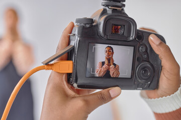 Close up of photographer holding camera with portrait of Black young woman on screen during photoshoot in studio, copy space