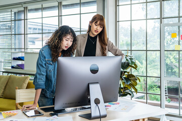 Collaboration of graphic design business people with computer in an office company, Two corporate women in creative marketing team working on project management