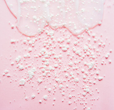 Cosmetic products on a pink background. Sample of enzyme powder and clear liquid cosmetics. Texture of cosmetic skin care product