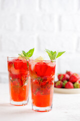 Fresh mocktail or cocktail with strawberries, mint and lime. Strawberry mojito. Refreshing red drink, sugar free. Vertical orientation.