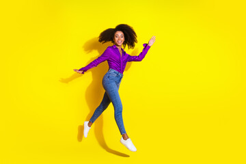 Full body photo of pretty young girl running jump wear trendy violet outfit isolated on yellow color background