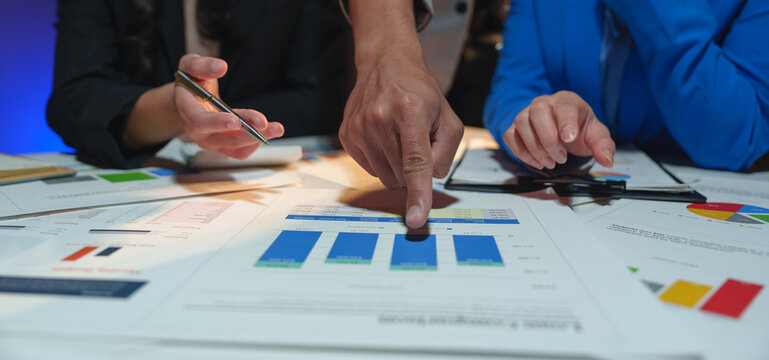 Businesswoman teamwork discussing brainstorming and calculating with calculator on evaluation data in conference room Focus on business growth and point out financial accounting charts.