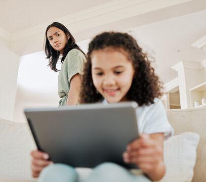 Girl, internet and tablet for streaming in house for social media, cartoon and movie with stress or concern. Child, online and technology for app, games or film with mother as parental guidance worry