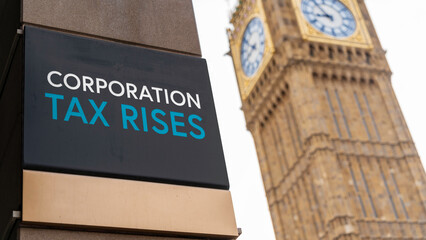 Corporation Tax Rises sign in front of Westminster	