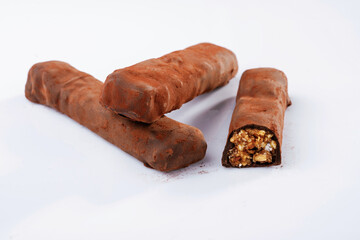 Brown colored chocolate bars lie on a white surface, isolated