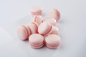 Pink colored. Bunch of macarons on the white surface